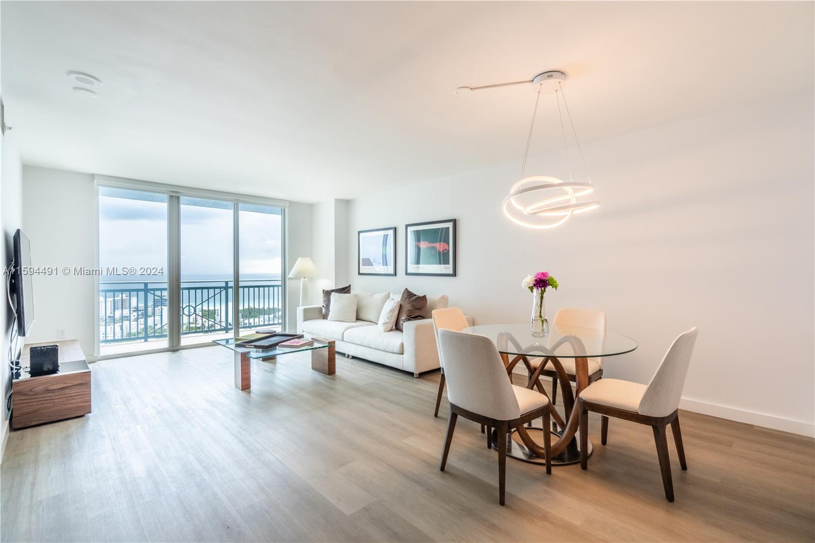 90 Alton Road, Unit 2807 Miami Beach, FL 33139 - Photo 2 of 27 a view of a livingroom with furniture wooden floor and a floor to ceiling window