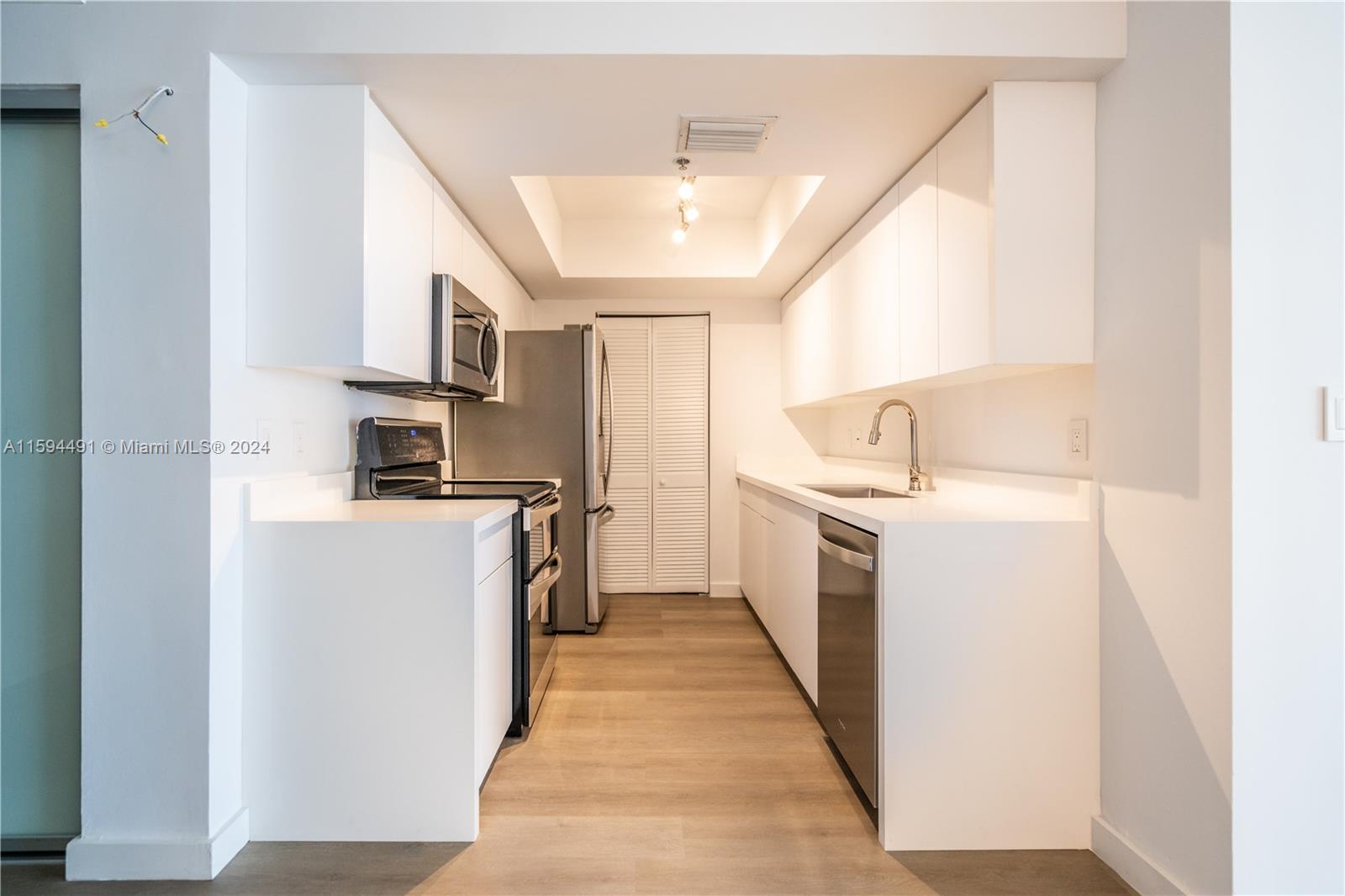 90 Alton Road, Unit 2807 Miami Beach, FL 33139 - Photo 9 of 27 a kitchen with cabinets a sink and stainless steel appliances