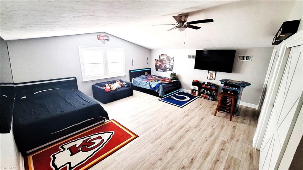 3690 27th Avenue Southwest Naples, FL 34117 - Photo 20 of 32 2nd Floor Master Bedroom featuring ceiling fan, visible vents, baseboards, wood finished floors, and vaulted ceiling