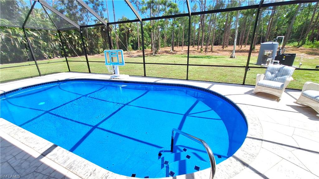 3690 27th Avenue Southwest Naples, FL 34117 - Photo 5 of 32 Outdoor pool with glass enclosure, a patio, and a yard