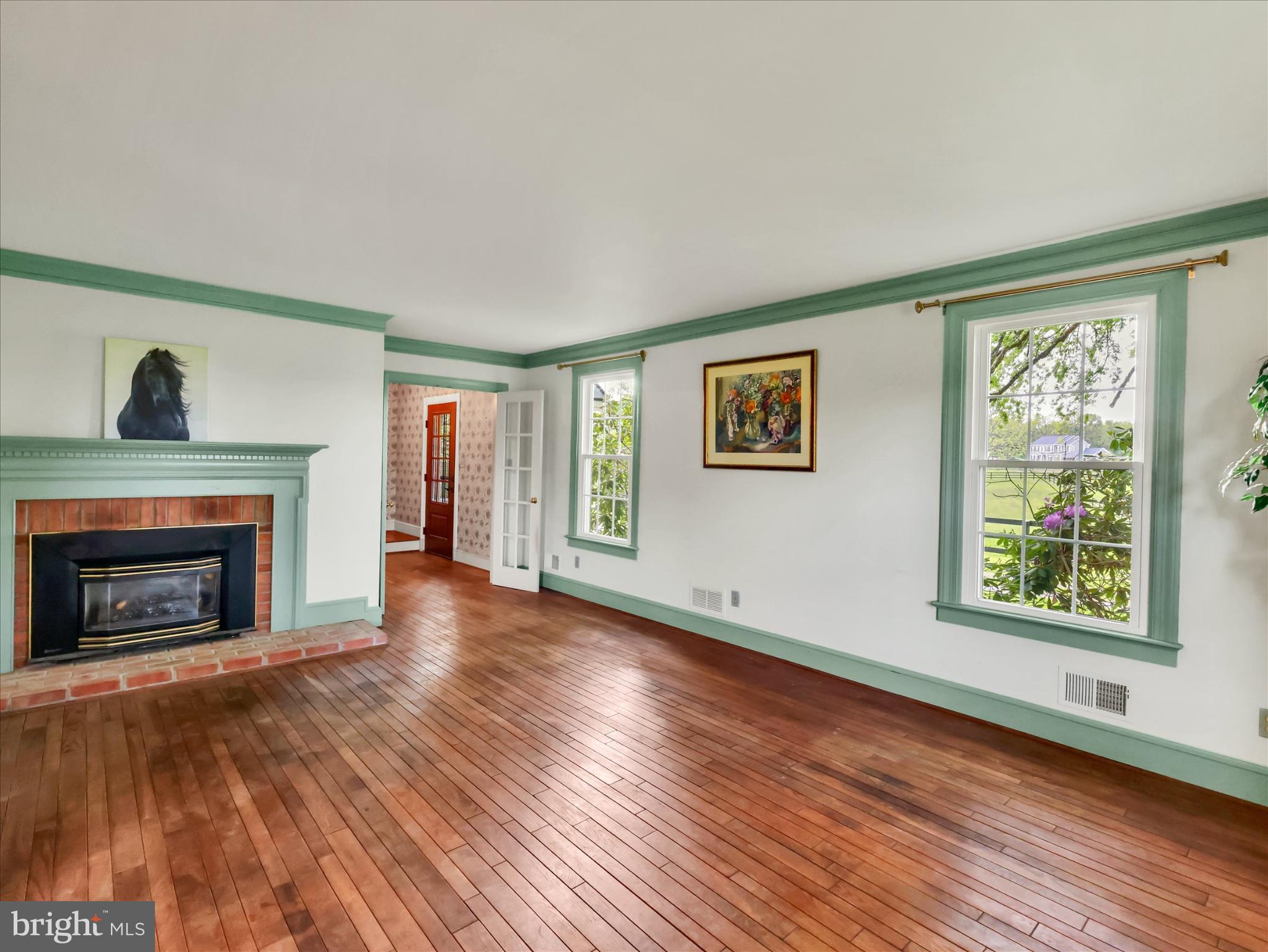 19255 Telegraph Springs Road Purcellville, VA 20132 - Photo 9 of 107 a view of an empty room with wooden floor fireplace and a window