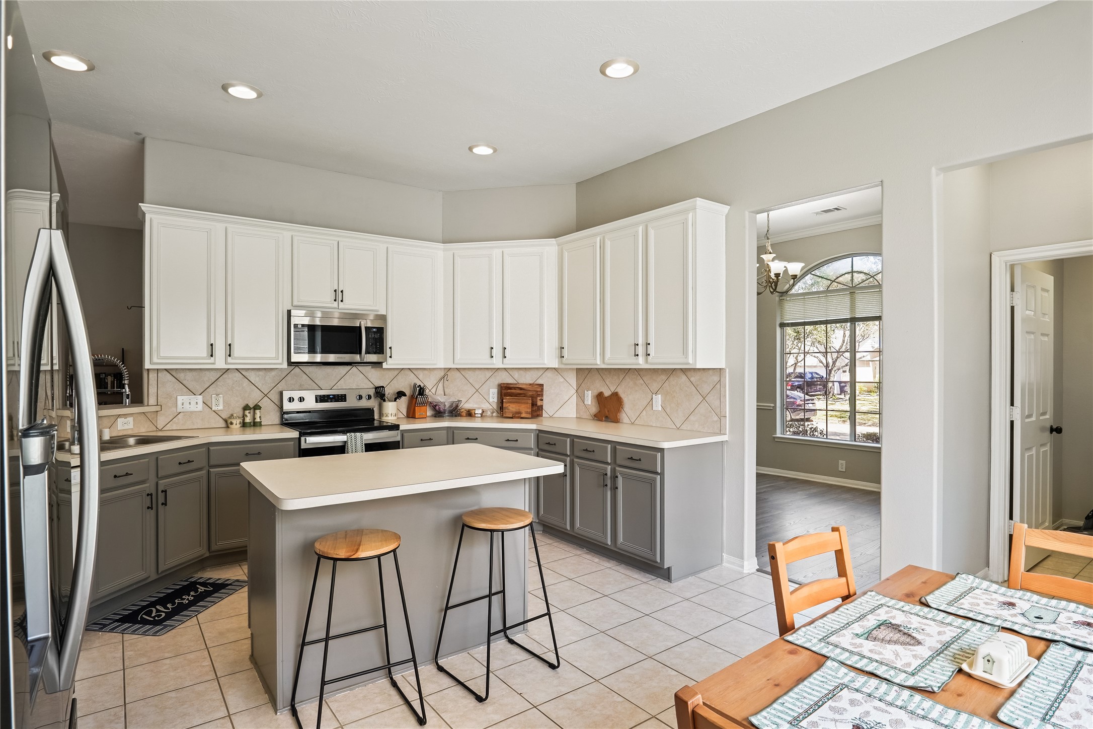 5710 Shady Hollow Court Rosharon, TX 77583 - Photo 12 of 25 a kitchen that has a lot of cabinets in it with stainless steel appliances granite countertop a stove a refrigerator a sink a dining table and chairs with wooden floor