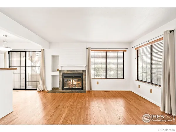 a view of an empty room with a fireplace and a window