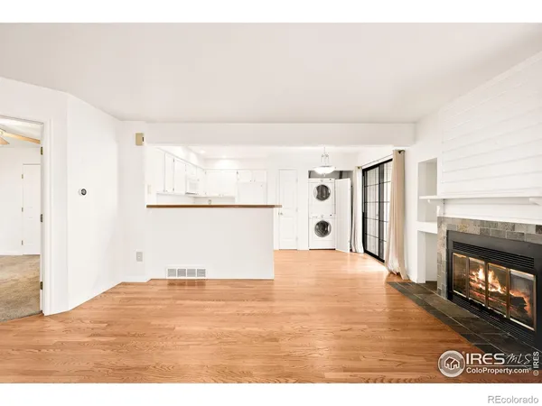 a view of empty room with wooden floor and fireplace