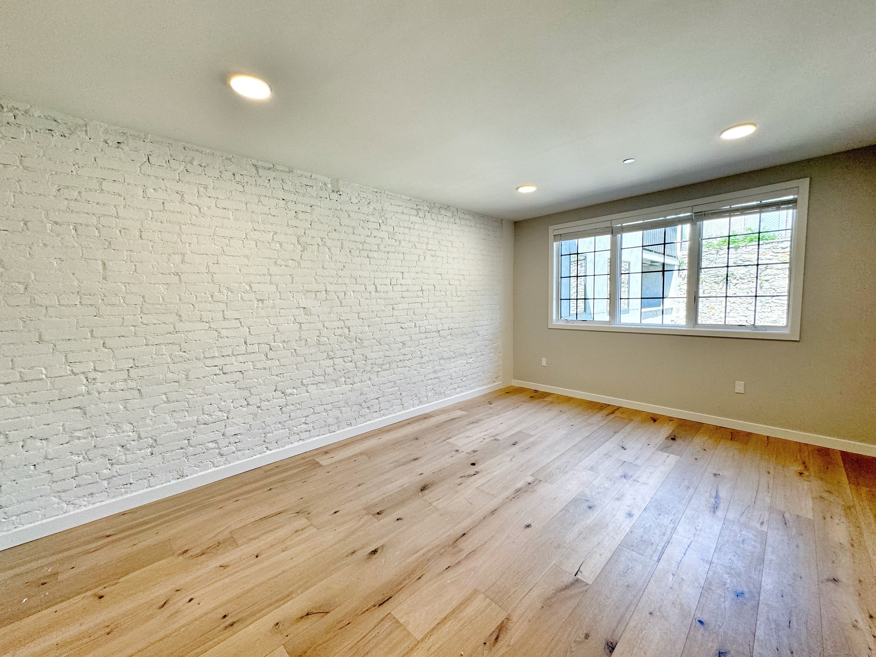32 Main Street, Unit 201 Norwalk, CT 06851 - Photo 1 of 8 wooden floor in an empty room with a window