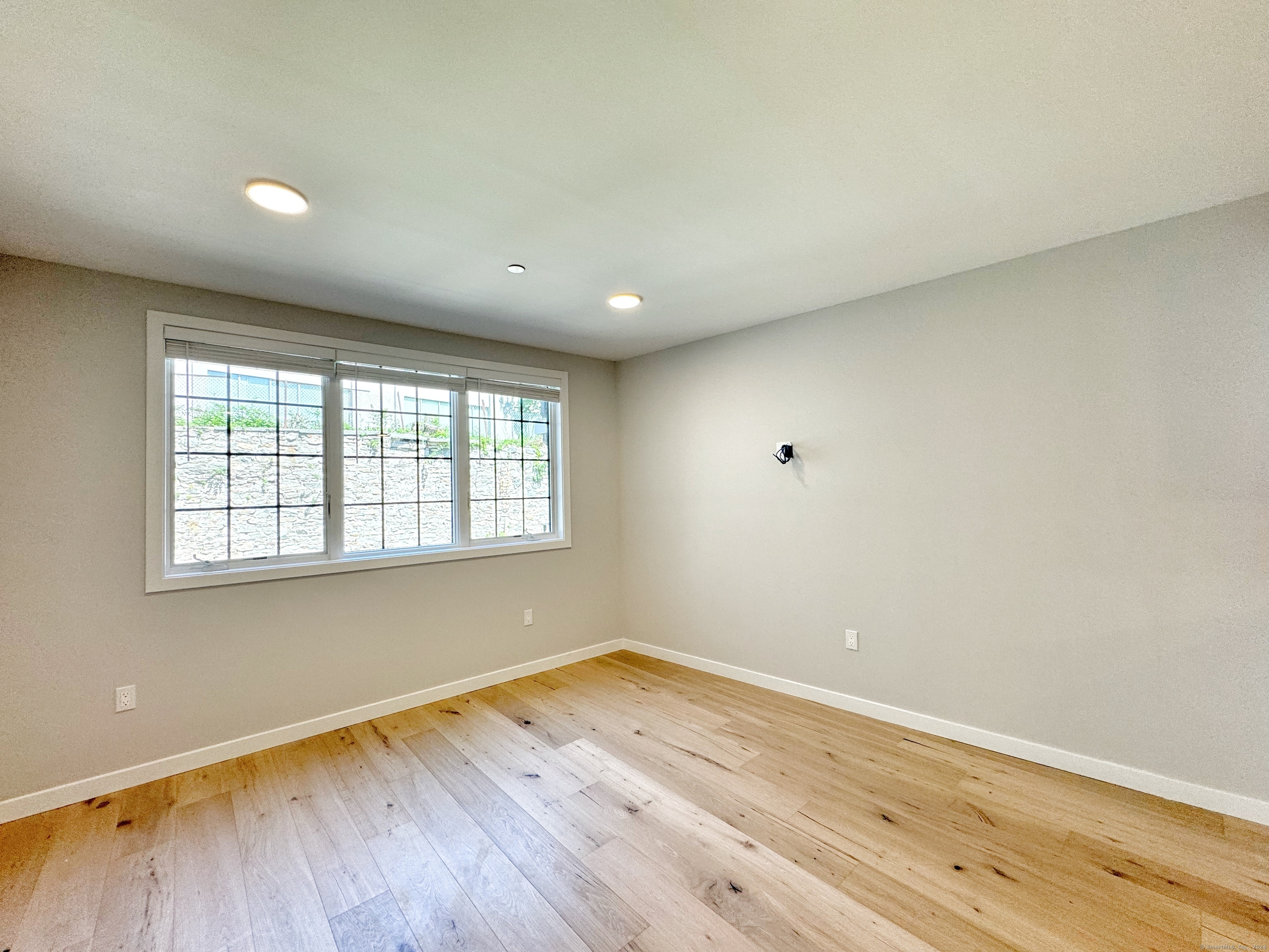 32 Main Street, Unit 201 Norwalk, CT 06851 - Photo 2 of 8 an empty room with wooden floor and windows