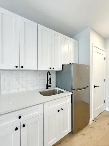 a kitchen with refrigerator and cabinets