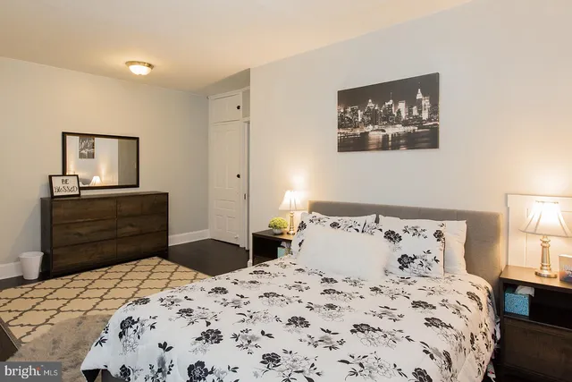 a bedroom with a bed and a lamp on dresser