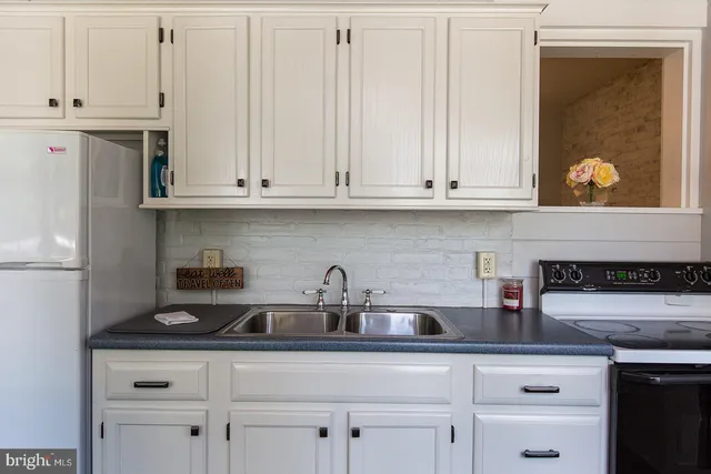a kitchen with white cabinets and a sink