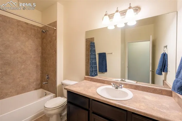 a bathroom with a granite countertop sink toilet a large mirror a shower and a bathtub