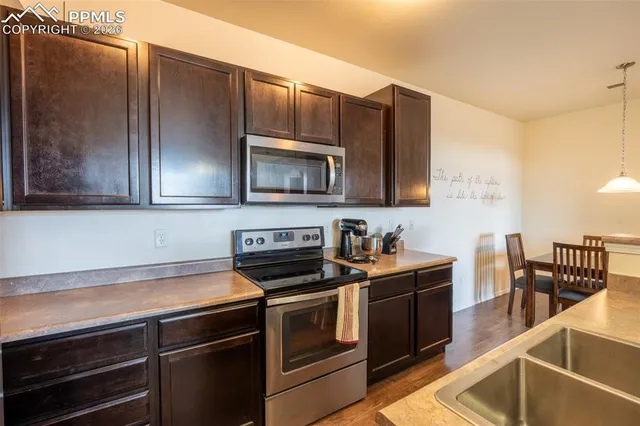 a kitchen with stainless steel appliances a stove microwave and sink