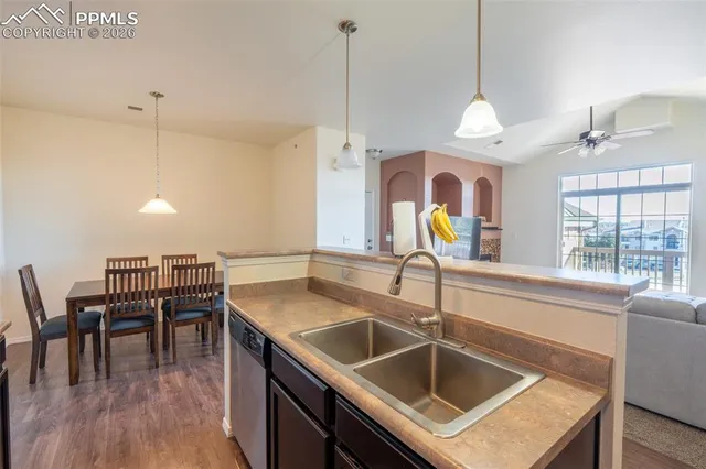 a kitchen with a sink a counter space appliances and cabinets