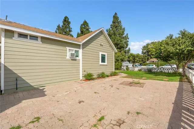 a view of a house with a yard and potted plants