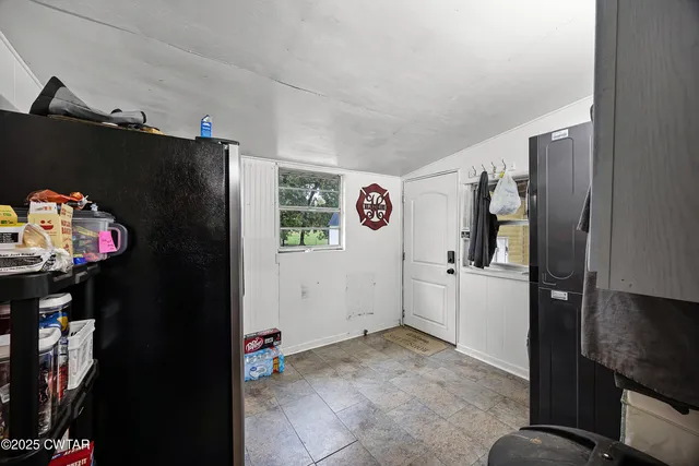 a view of a kitchen with fridge and workspace