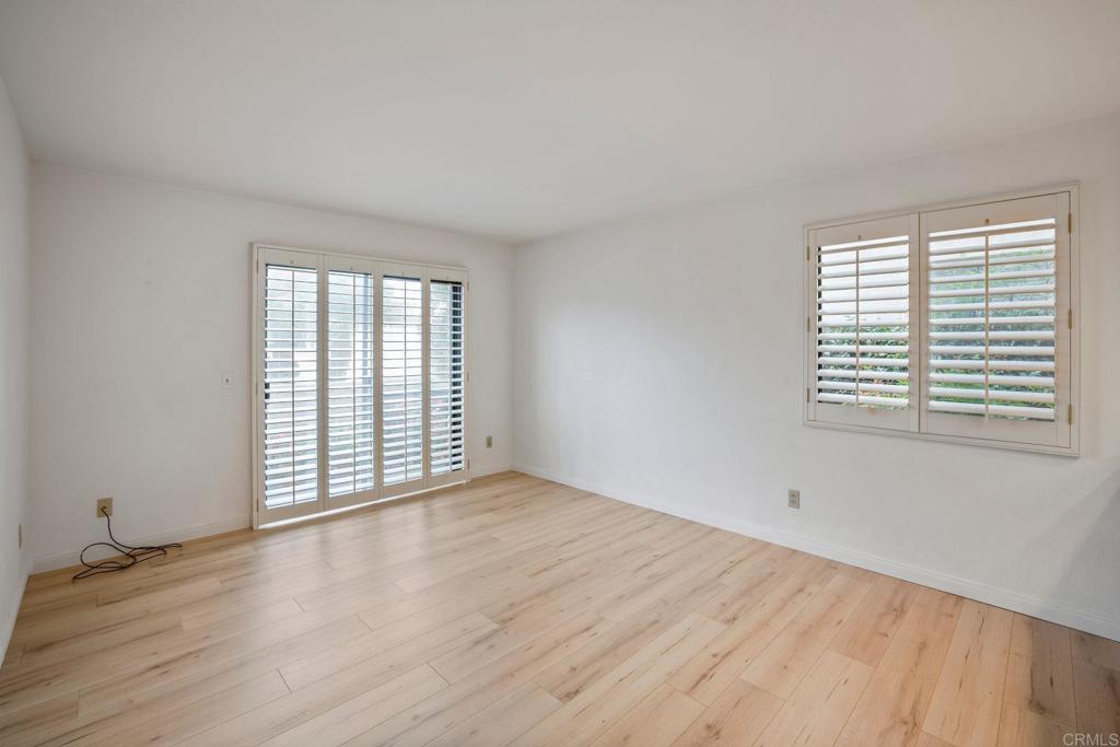 6882 Batiquitos Drive Carlsbad, CA 92011 - Photo 13 of 47 an empty room with wooden floor and windows