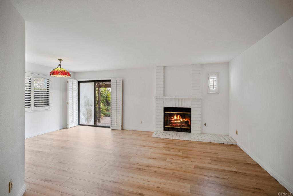 6882 Batiquitos Drive Carlsbad, CA 92011 - Photo 4 of 47 a view of an empty room with wooden floor fireplace and a window