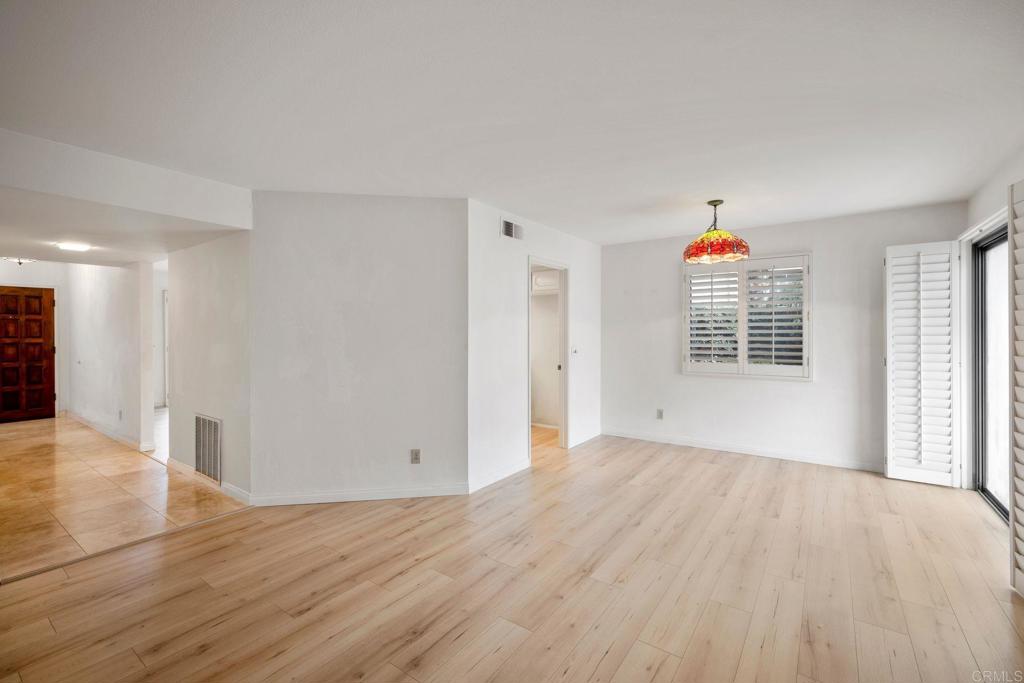 6882 Batiquitos Drive Carlsbad, CA 92011 - Photo 6 of 47 a view of an empty room with wooden floor and a window
