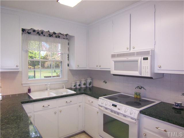 6915 Innesbrook Way Bahama, NC 27503 - Photo 6 of 15 a kitchen with granite countertop a sink stove and cabinets
