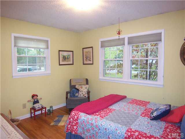 6915 Innesbrook Way Bahama, NC 27503 - Photo 10 of 15 a bedroom with a bed and wooden floor