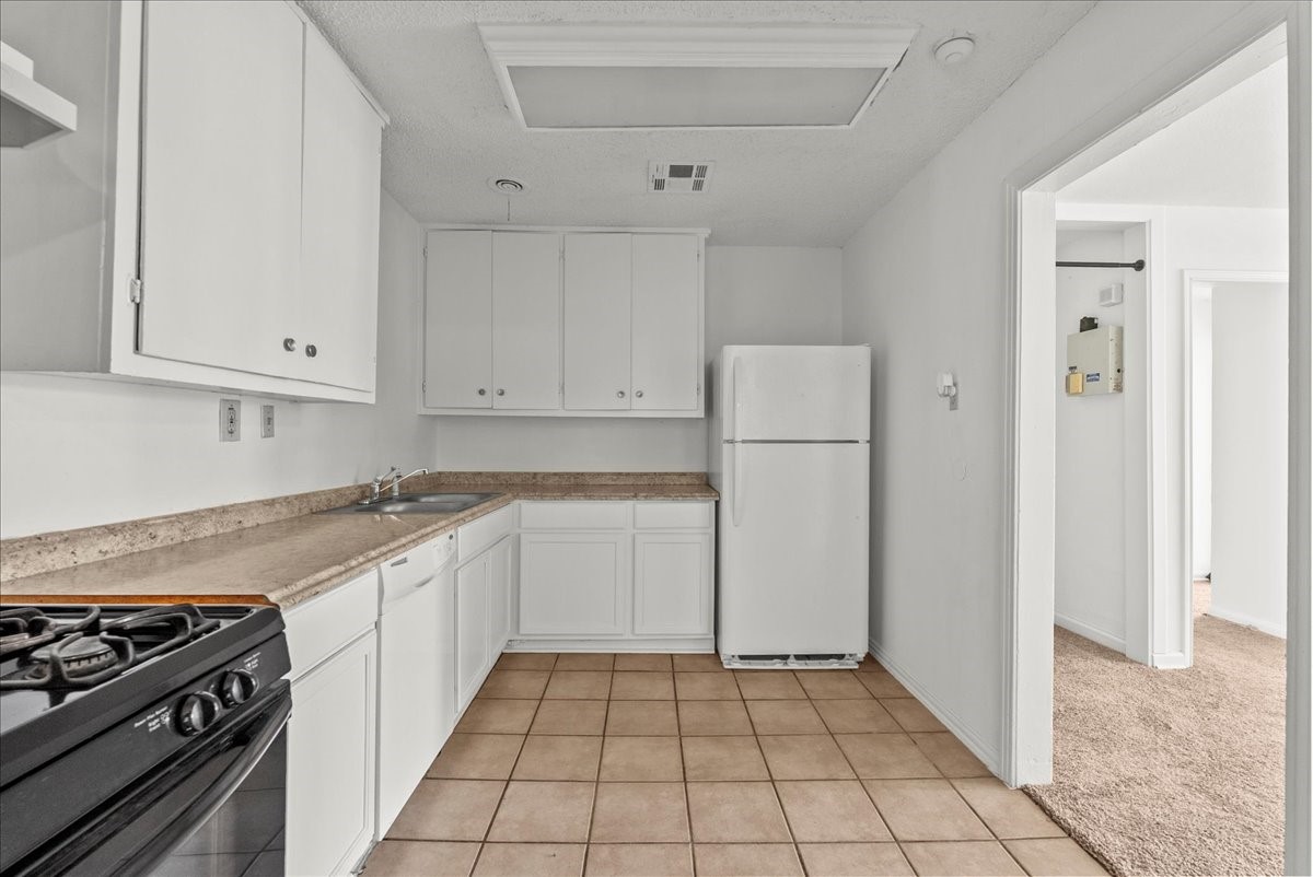 1002 Orange Street La Marque, TX 77568 - Photo 2 of 31 a kitchen with white cabinets and appliances