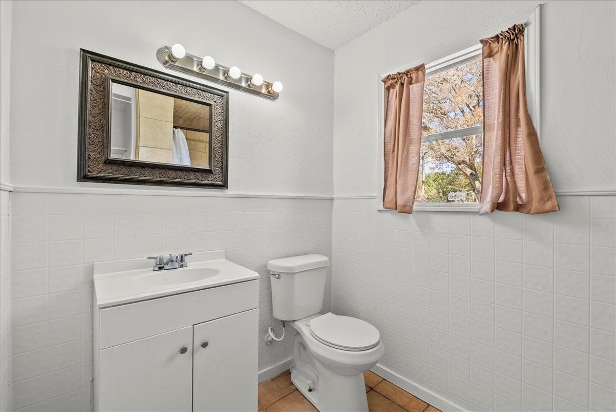 1002 Orange Street La Marque, TX 77568 - Photo 5 of 31 a bathroom with a toilet a sink and mirror