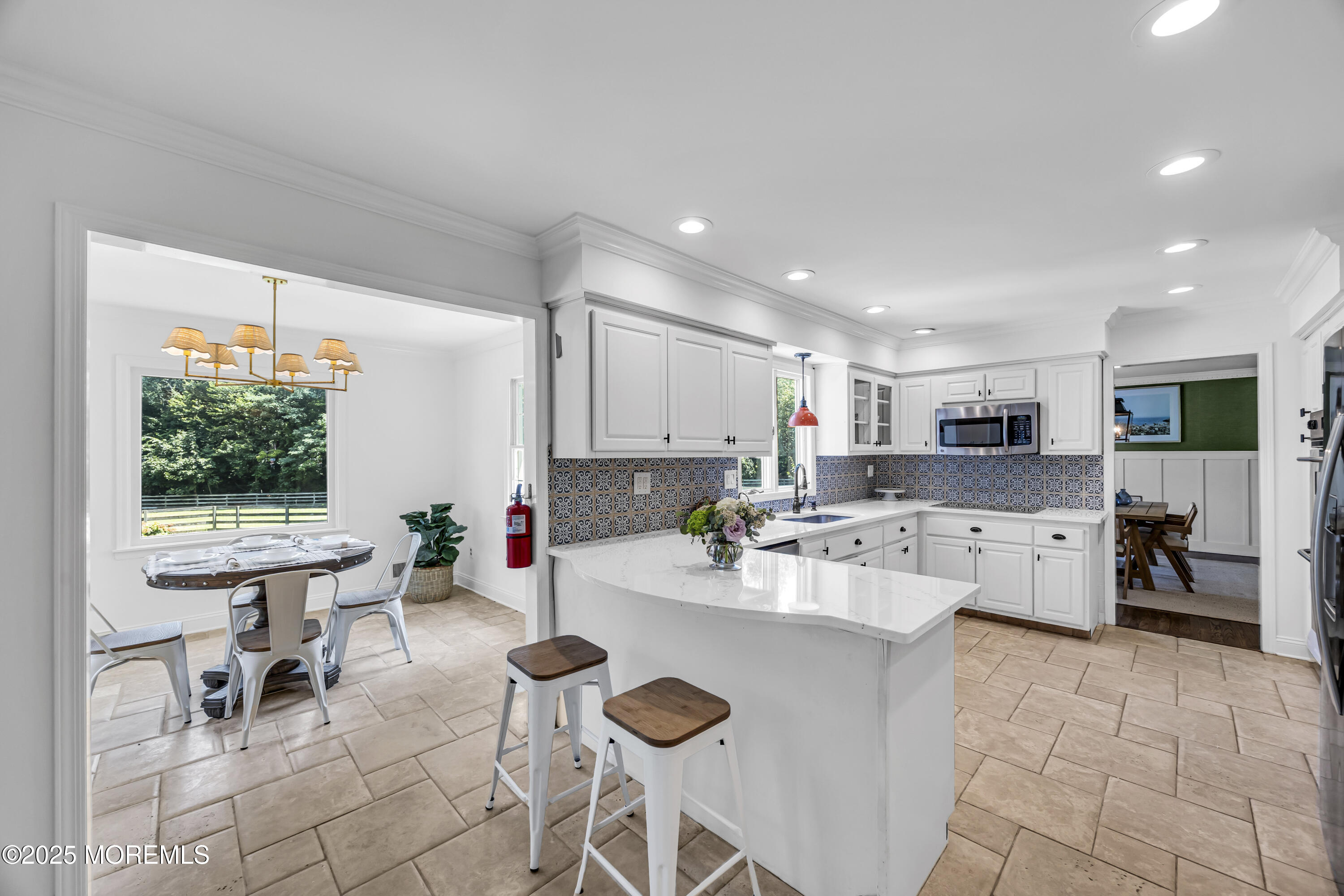 39 Hockhockson Road Colts Neck, NJ 07722 - Photo 29 of 72 a kitchen with a dining table chairs stove and white cabinets