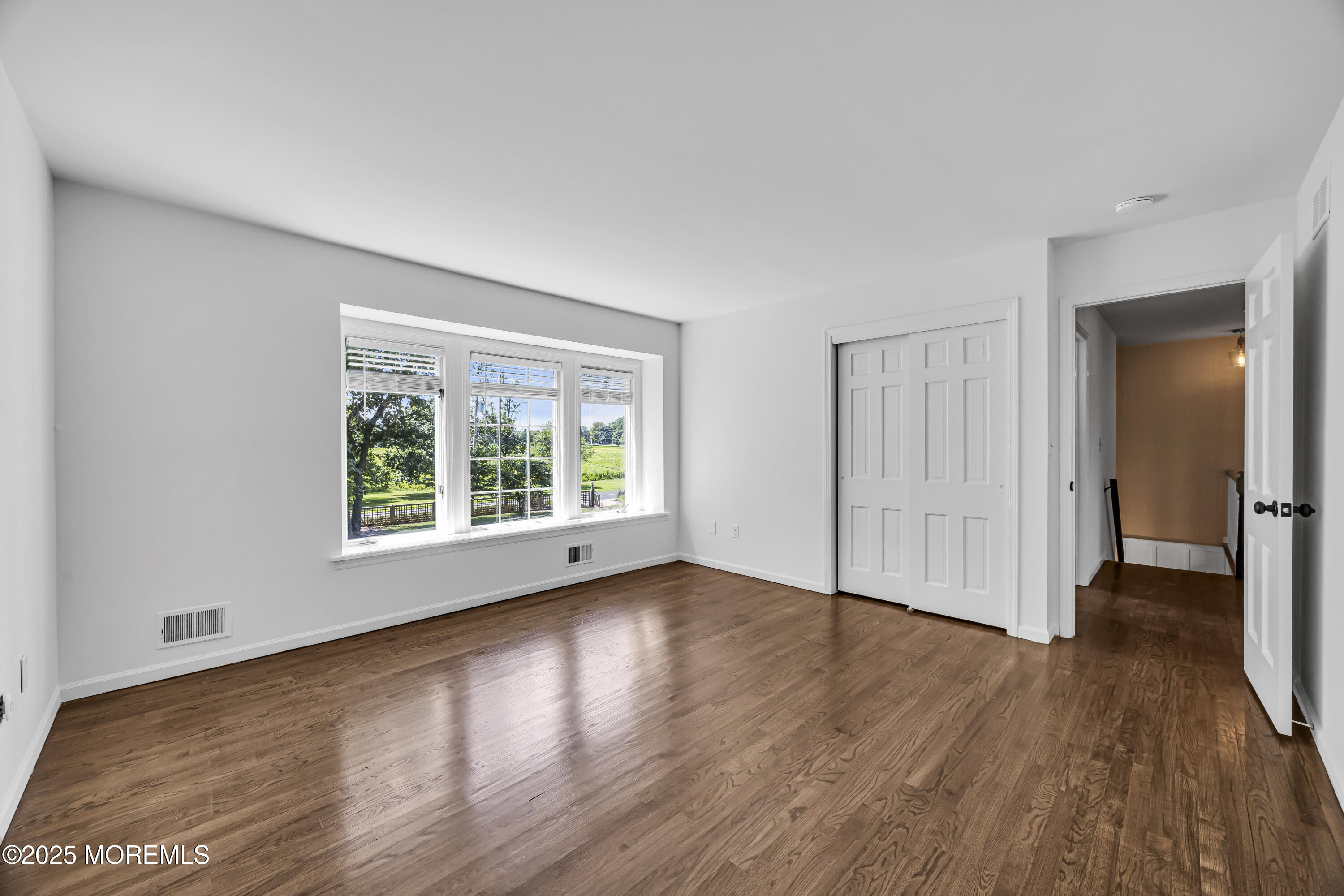 39 Hockhockson Road Colts Neck, NJ 07722 - Photo 39 of 72 an empty room with wooden floor and windows