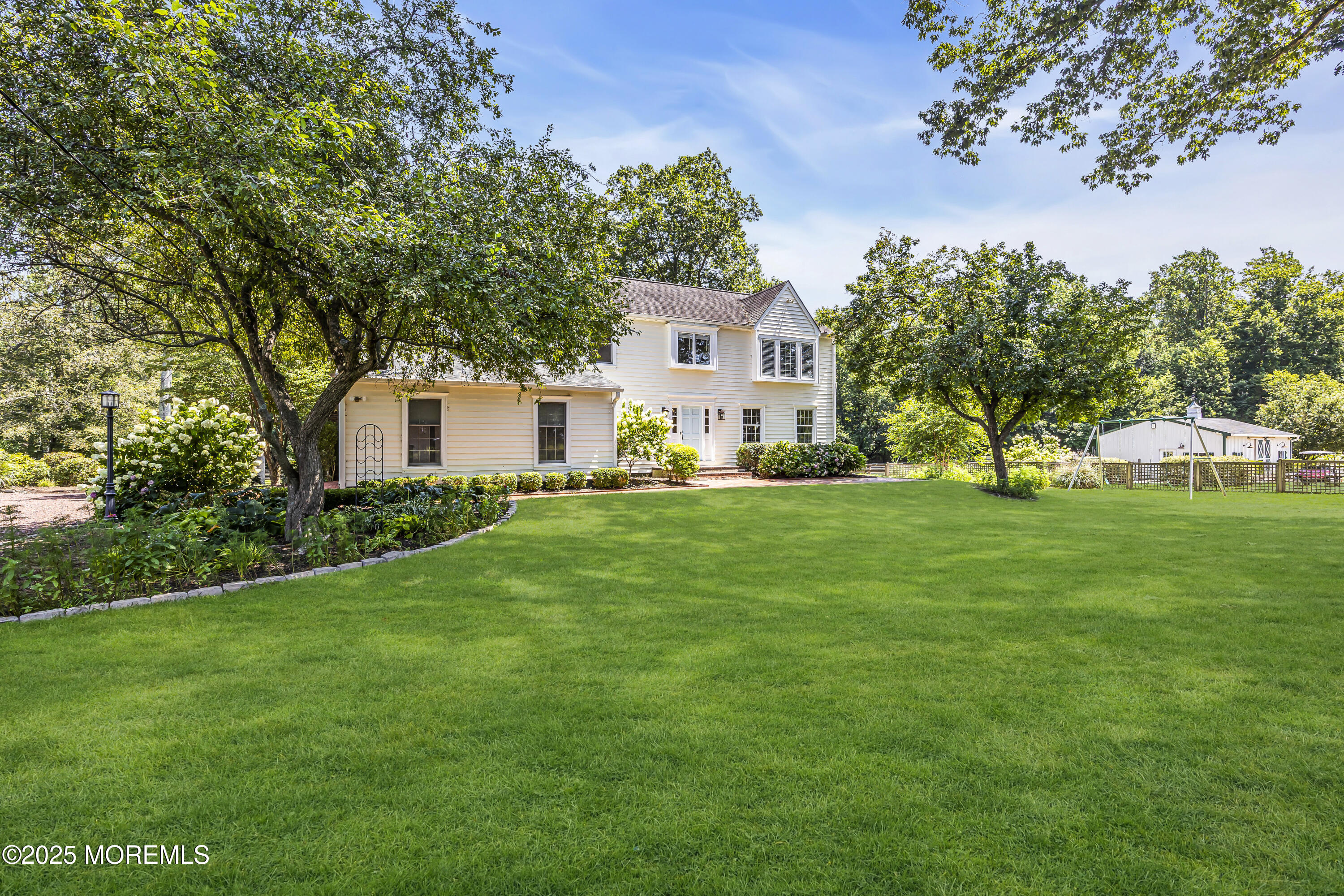39 Hockhockson Road Colts Neck, NJ 07722 - Photo 8 of 72 a front view of a house with garden and trees