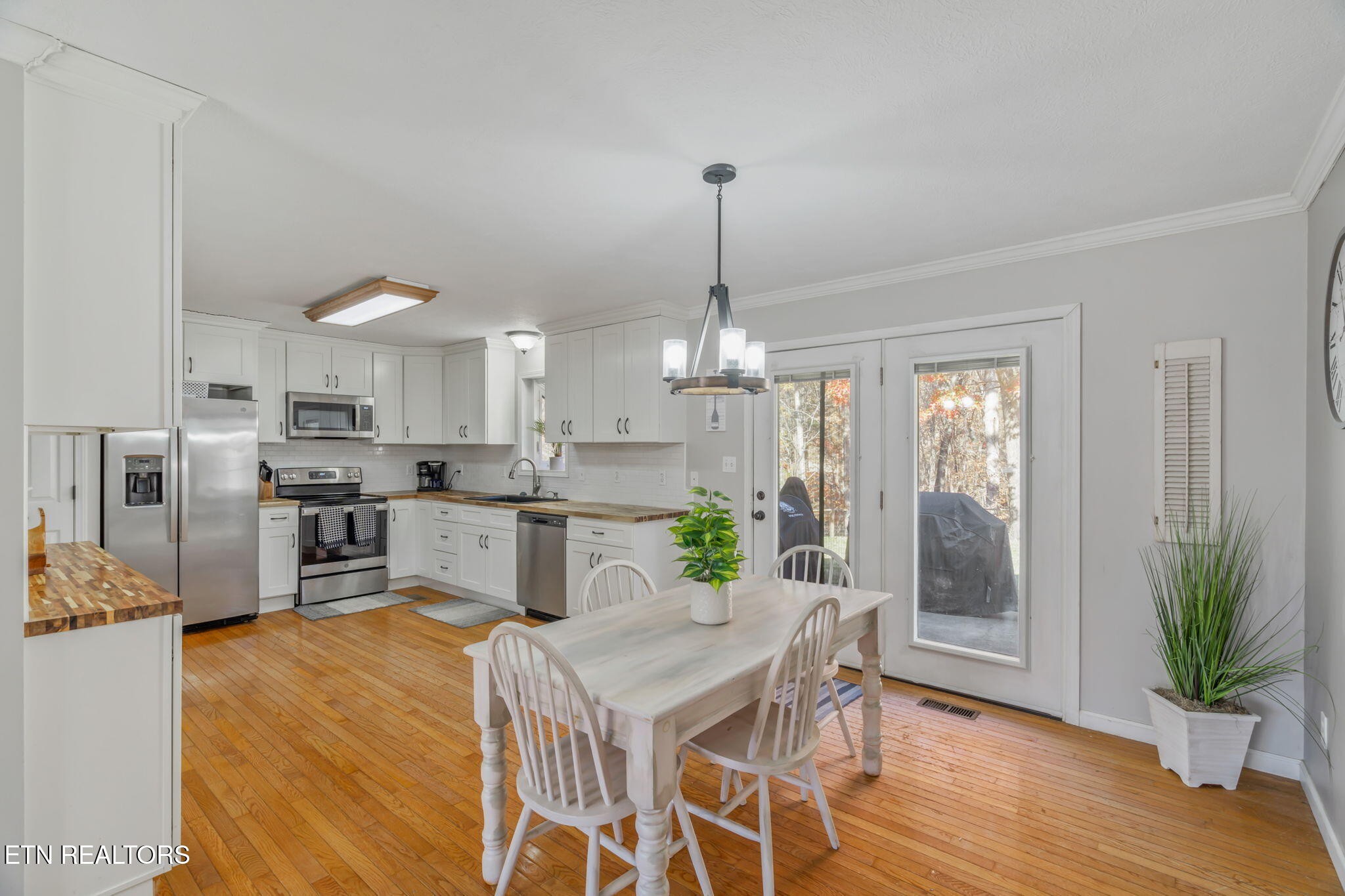 172 Edgewood Drive Powell, TN 37849 - Photo 9 of 29 a kitchen with stainless steel appliances kitchen island granite countertop a refrigerator a stove a sink dishwasher and white cabinets with wooden floor