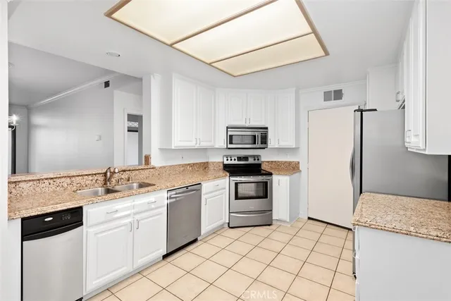 a kitchen with white cabinets and white appliances