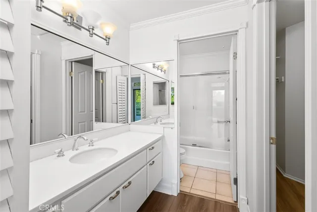 a bathroom with a granite countertop sink a mirror and shower
