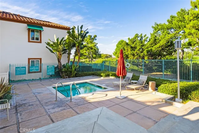 a view of backyard with swimming pool and seating space