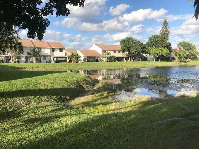 3405 Poolside Drive Greenacres, FL 33463 - Photo 13 of 32 a view of a lake with a building in the background