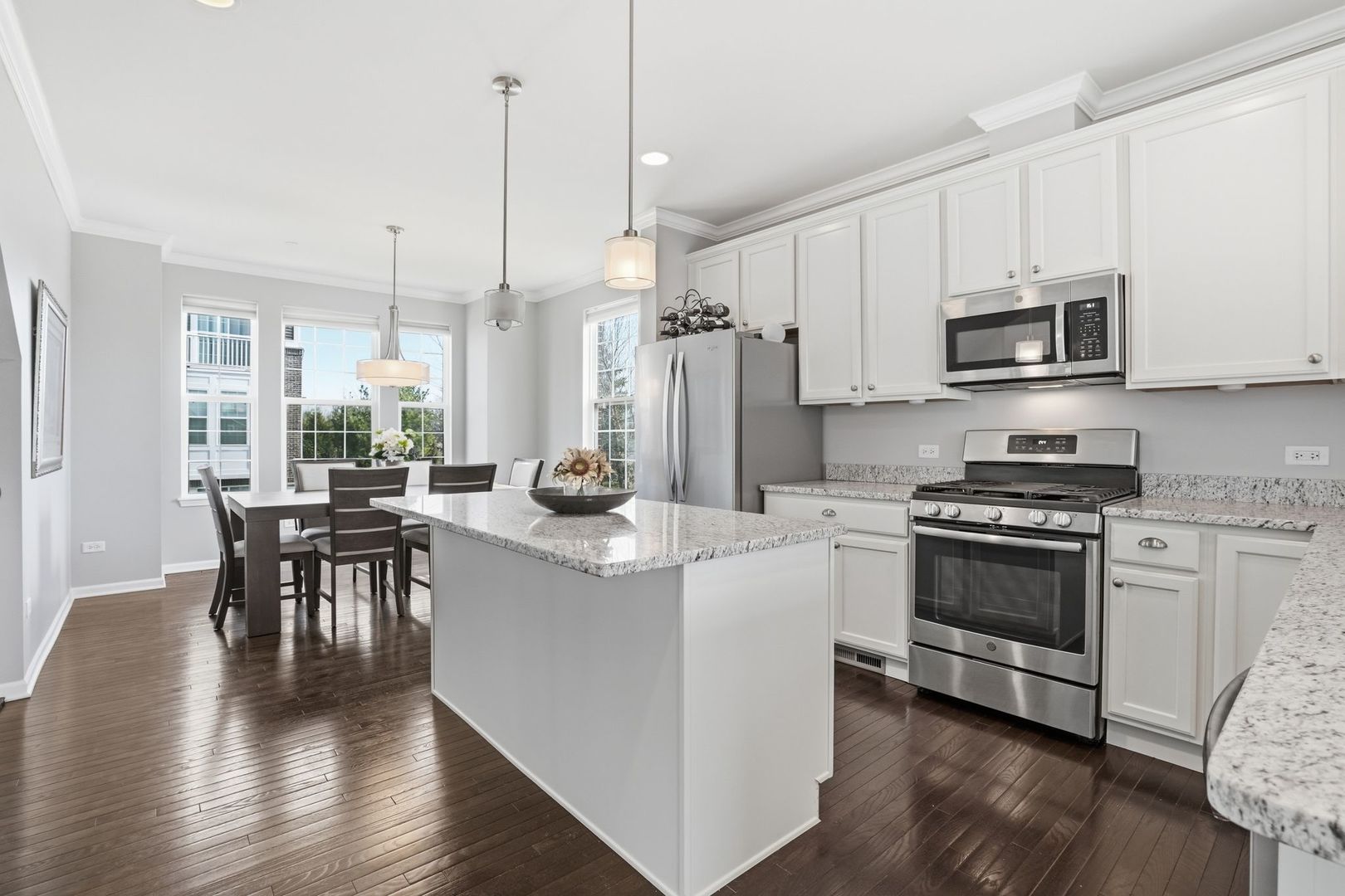 2925 Madison Drive Naperville, IL 60564 - Photo 4 of 37 a kitchen with stainless steel appliances a stove a sink a microwave a dining table and chairs