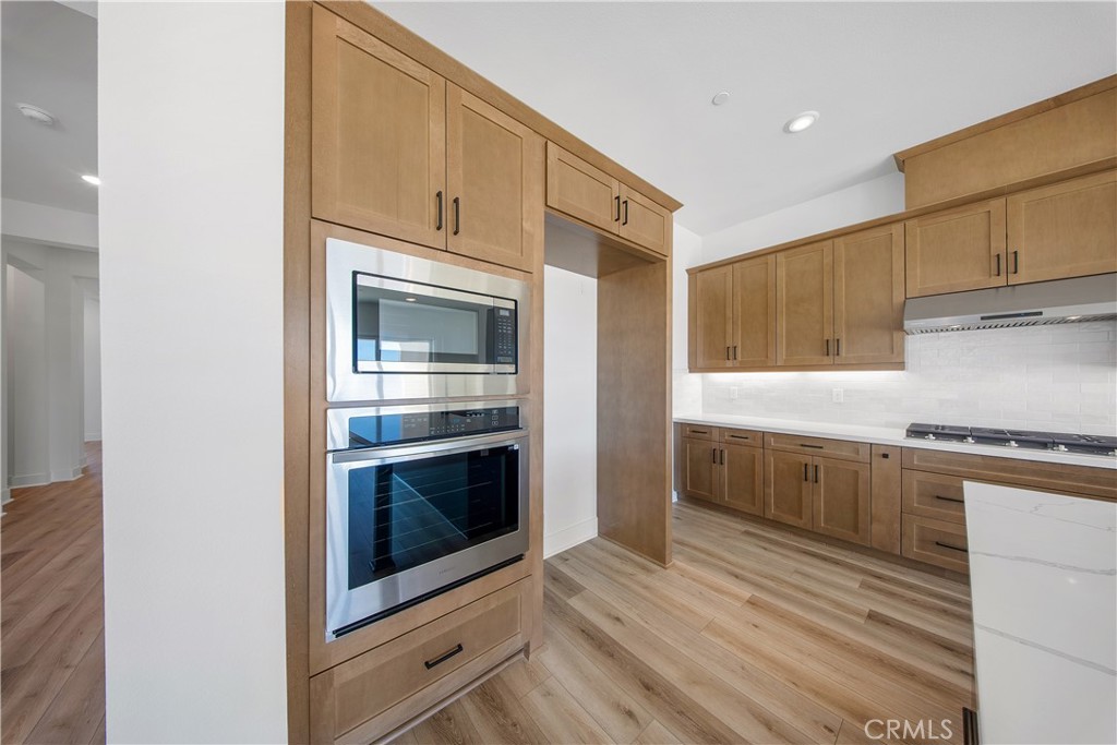 28632 Old Spgs Road Castaic, CA 91384 - Photo 15 of 70 a kitchen with granite countertop white cabinets stainless steel appliances and wooden floor
