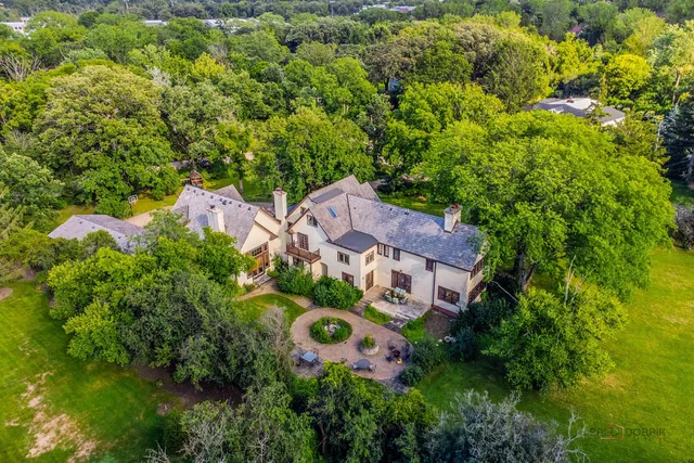 an aerial view of a house with swimming pool and garden