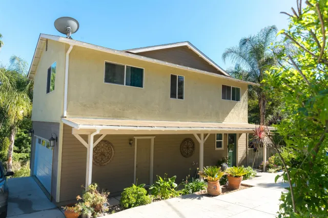 a front view of a house with plants