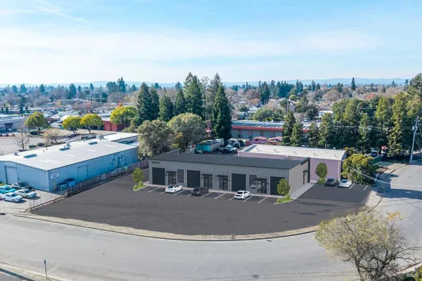 a terrace of a house with outdoor seating and trees in the background
