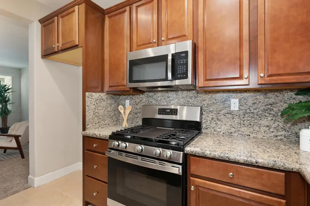 a kitchen with granite countertop a stove and a microwave