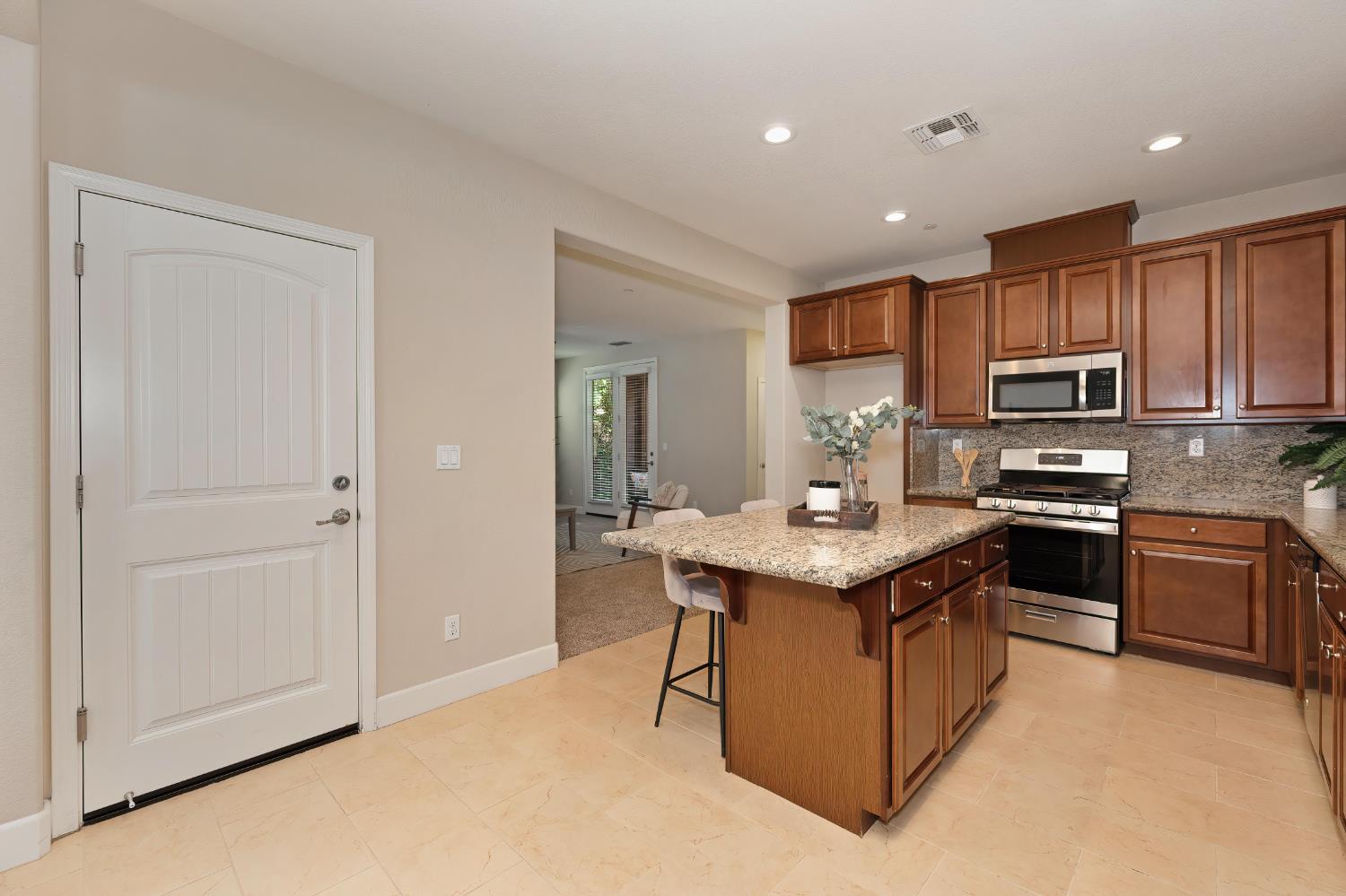 908 Lyon Place Roseville, CA 95747 - Photo 12 of 31 a kitchen with kitchen island granite countertop stainless steel appliances a sink a stove a refrigerator cabinets and a window