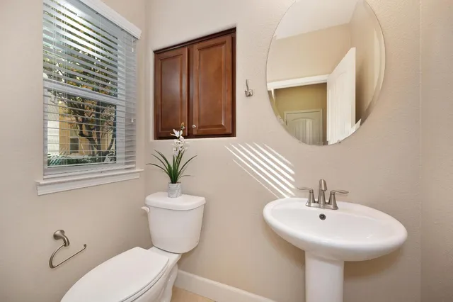a bathroom with a toilet a sink and a mirror