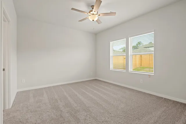 an empty room with a window and a fan
