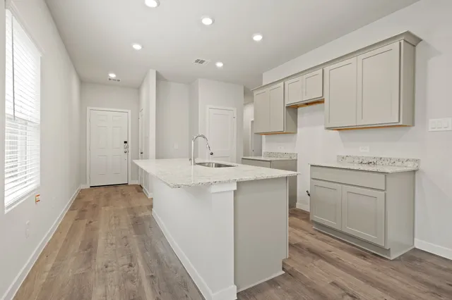 a kitchen with sink stove and cabinets