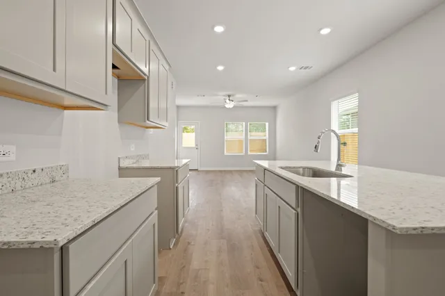 a kitchen with granite countertop kitchen island a sink appliances and cabinets
