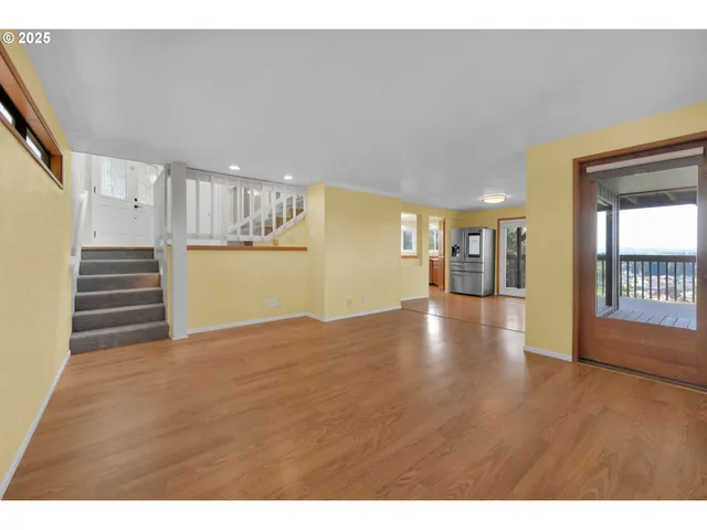 a view of a hallway with wooden floor and windows