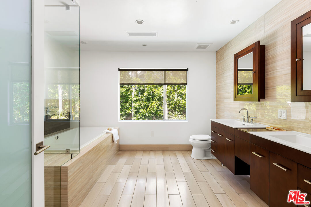 1600 North Kings Road Los Angeles, CA 90069 - Photo 28 of 37 a spacious bathroom with a double vanity sink a large mirror and a bathtub