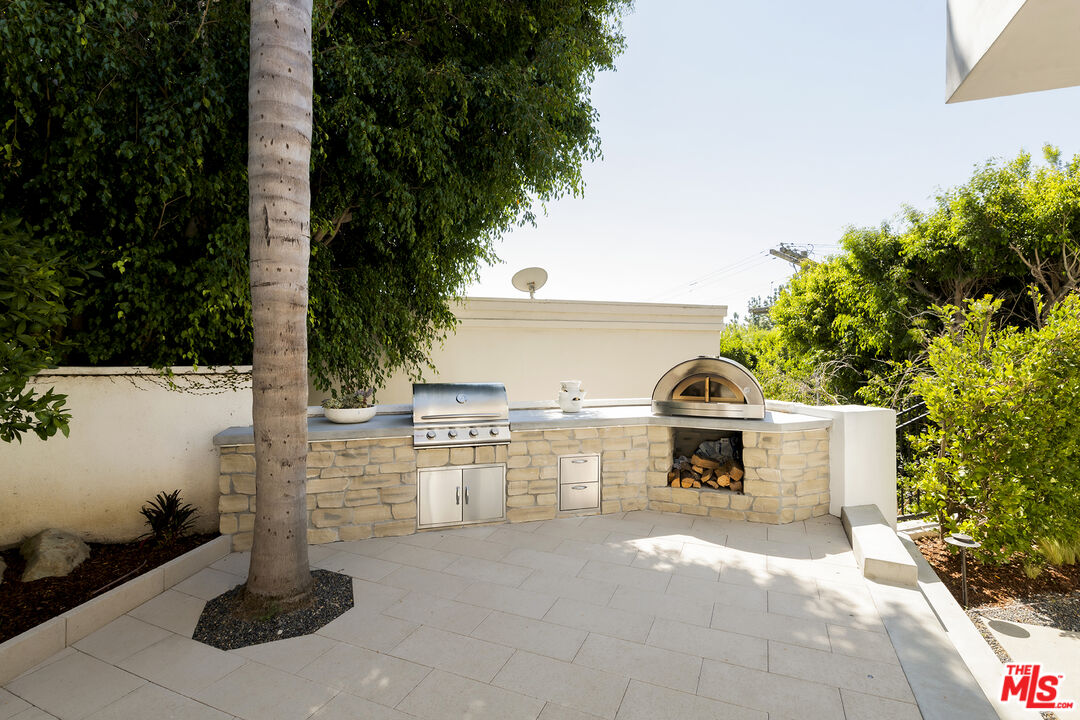 1600 North Kings Road Los Angeles, CA 90069 - Photo 31 of 37 a view of a patio with table and chairs a barbeque with wooden fence