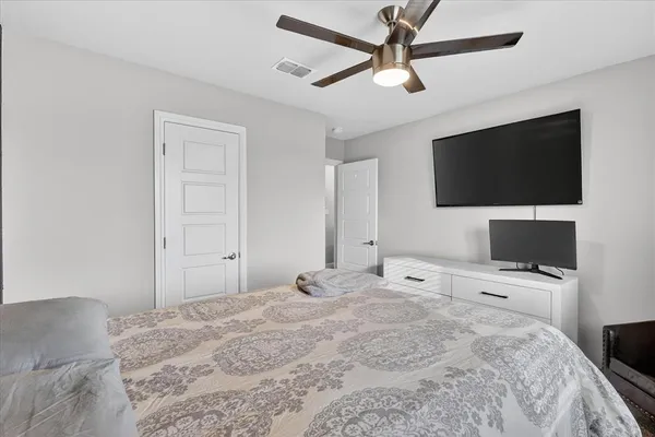 a bedroom with a bed window and a flat screen tv