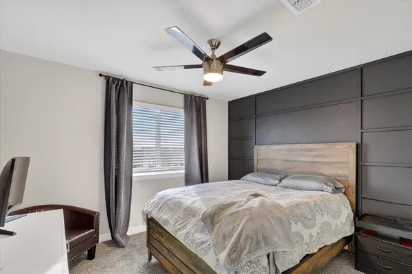 a bedroom with a bed and a ceiling fan