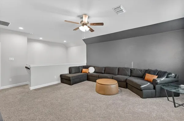 a living room with furniture and a chandelier fan